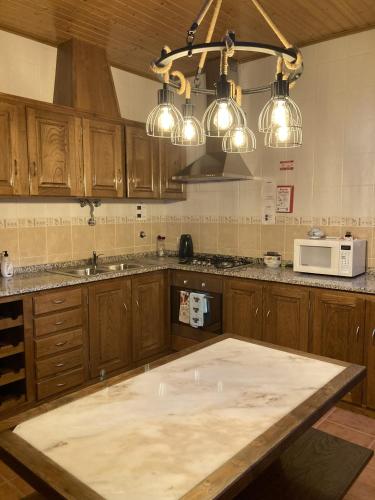 a kitchen with a large island in the middle at Casa do Tavares in Carvalhais