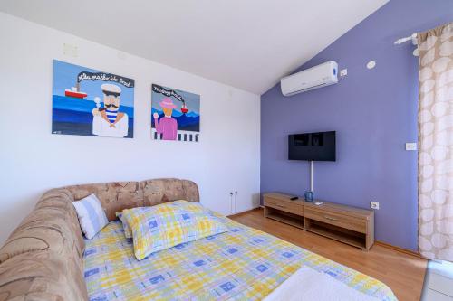 a bedroom with a bed and a flat screen tv at Apartman More in Šibenik