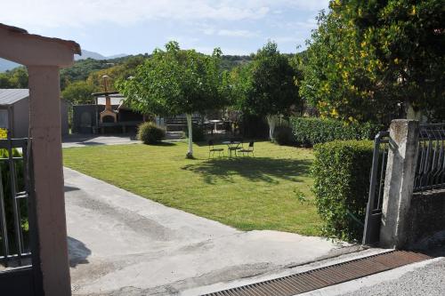 a view of a yard with a fence and grass at The Other Side of Meteora with lush garden, BBQ & pavillion in Kalabaka