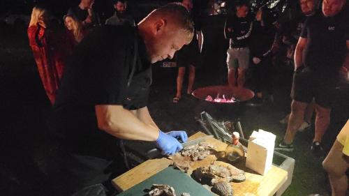 a man cutting up food on a cutting board at Neitsijärve majutus in Otepää