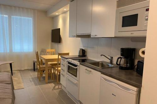una cocina con fregadero y estufa horno superior en Arctic Star Levi - Lumitähti, en Levi