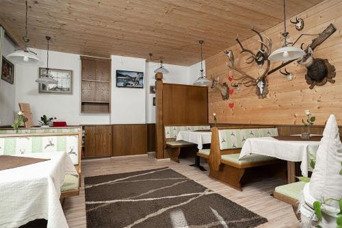 a dining room with two tables and chairs and wooden walls at Pension Berggeist in Sölden