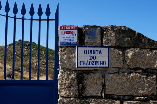 a sign on a stone wall next to a gate at Quinta do Chãozinho in Alijó