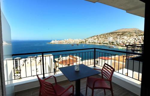 a balcony with a table and chairs and the ocean at AFRODITE SUITES in Sarandë