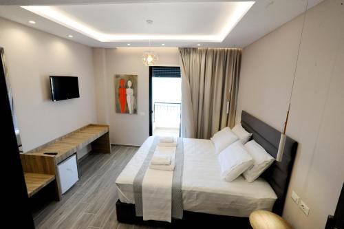 a hotel room with a bed and a tv at AFRODITE SUITES in Sarandë