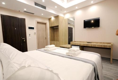 a bedroom with a bed and a tv on the wall at AFRODITE SUITES in Sarandë