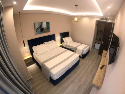 a hotel room with two beds and a television at AFRODITE SUITES in Sarandë