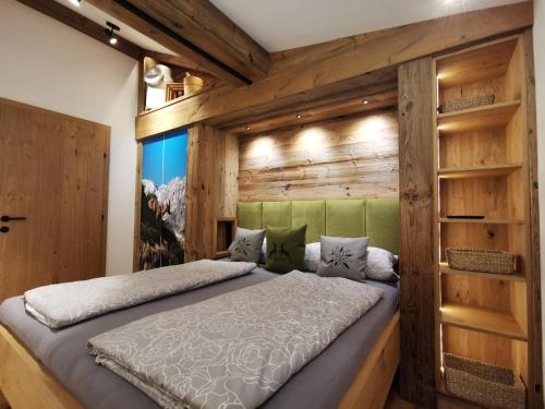 ein Schlafzimmer mit einem Bett in einer Holzwand in der Unterkunft Bauernhof Unterstegen in Söll