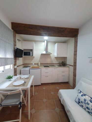 a kitchen with white cabinets and a table in a room at Hostal Canalejas in Cádiz