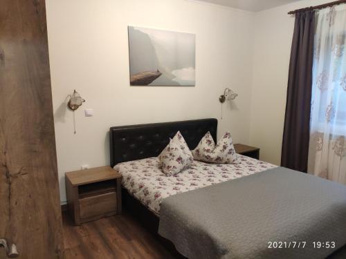 a bedroom with a bed with pillows on it at Cozy House Sinaia in Sinaia