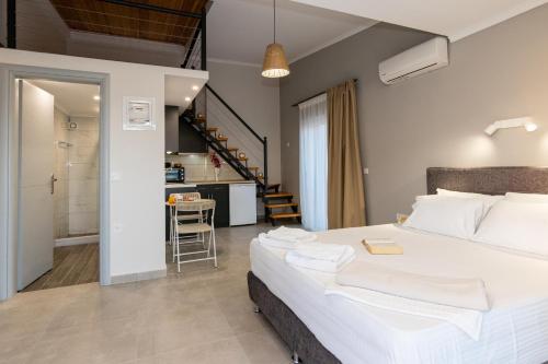 a bedroom with a large white bed and a kitchen at Elite City Apartments & Maisonettes in Lefkada Town