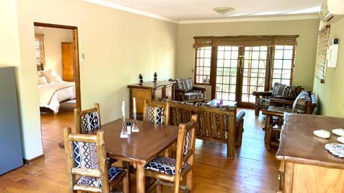 a dining room with a table and chairs and a bed at Hope Haven Cottage in Nelspruit