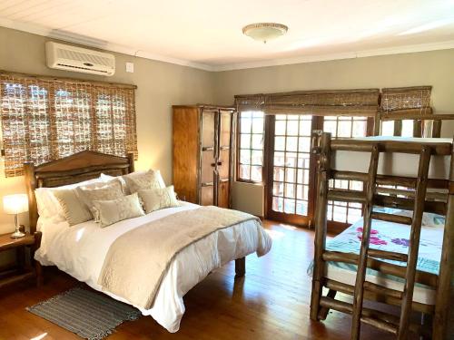 a bedroom with a bed and two bunk beds at Hope Haven Cottage in Nelspruit