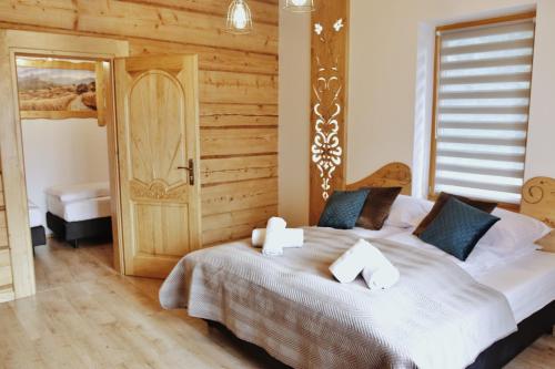ein Schlafzimmer mit einem großen Bett mit einer Holzwand in der Unterkunft Willa Strążyski Potok in Zakopane