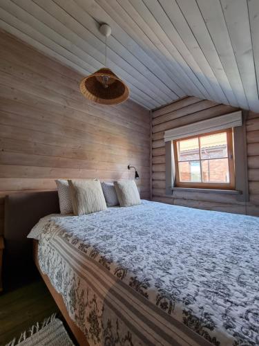 a bedroom with a bed in a wooden cabin at Rasos Vila in Palanga