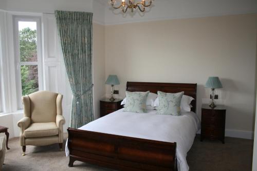 a bedroom with a bed and a chair and a window at Arrandale House in Pitlochry