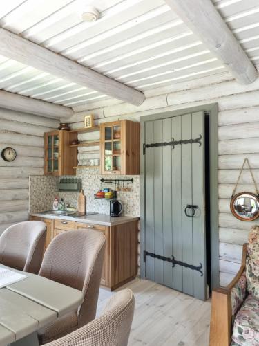 a kitchen with a table and chairs and a door at Rasos Vila in Palanga