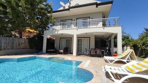 a villa with a swimming pool in front of a house at Villa Jasmin in Fethiye