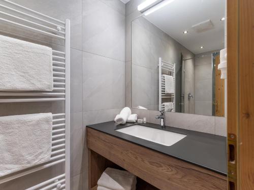 une salle de bain avec un lavabo et un miroir dans l'établissement Apart Denise, à Fügen