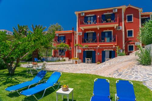 a resort with chairs and a table and a building at Aloe Studios, Waterfront Accommodation in Karavadhos