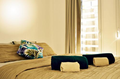 a bed with two pillows on it with a window at Corralejo Sun 103 wifi free in Corralejo