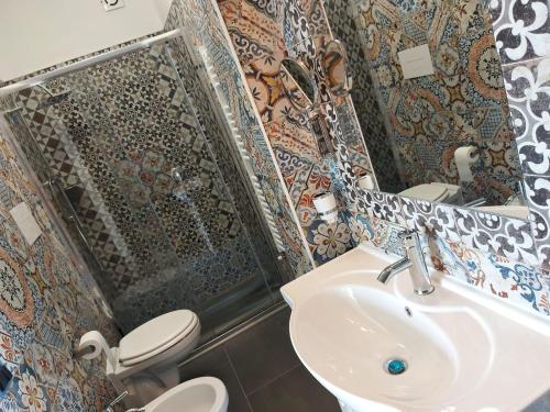 a bathroom with a sink and a toilet and a mirror at Casa del Sole in Ceraso