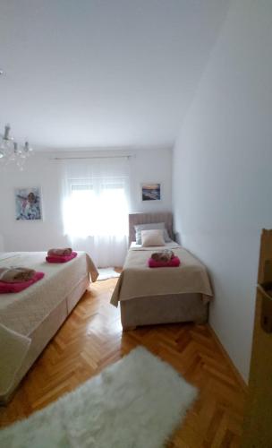 two beds in a room with a window at Apartman Miletic in Mostar