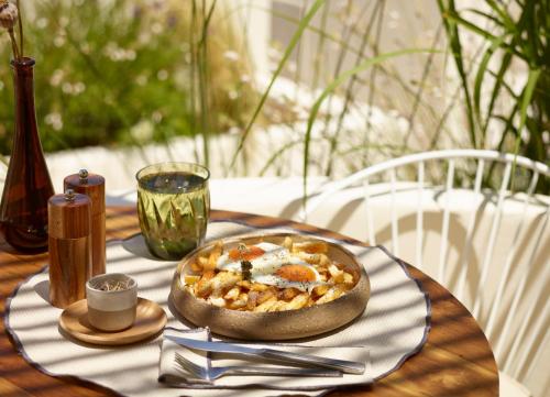 a table with a bowl of food on a table at White Pebble Suites in Pollonia