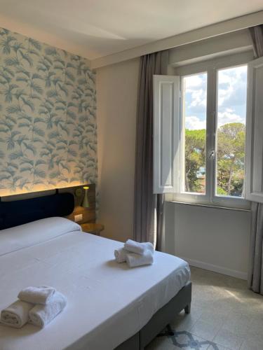a bedroom with a bed and a window at Guerrini Hotel in Castiglioncello