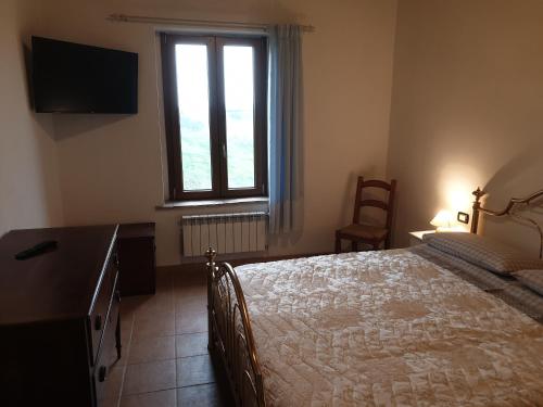 - une chambre avec un lit, une commode et une fenêtre dans l'établissement Podere Fogliano, à Sienne
