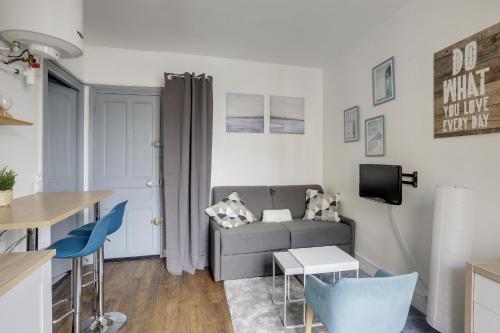 un salon avec un canapé et une table dans l'établissement Le Mousquetaire, à Versailles