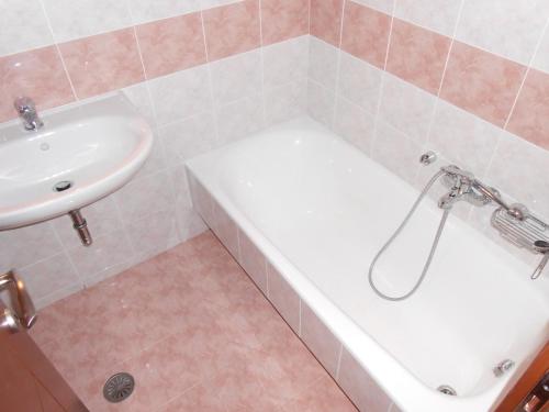 a bathroom with a bath tub and a sink at Chrysolithos Kerami Apartments in Khalkíon
