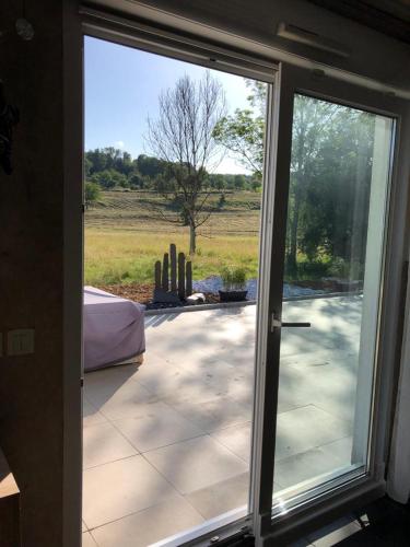 a sliding glass door leading to a patio with a cactus at Havre de paix dans le Jura Alsacien avec piscine privée externe de mai à septembre in Bendorf