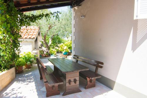 a wooden table and bench sitting on a patio at Villa Tereza in Splitska