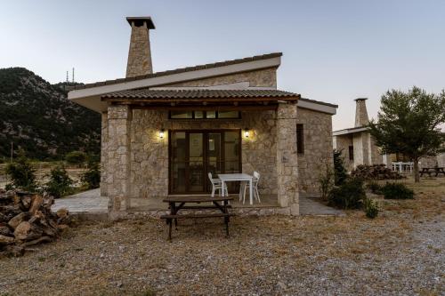 a small stone house with a table and chairs at Omalos Village in Omalós