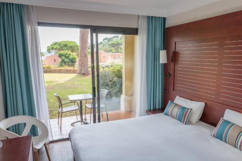 a hotel room with a bed and a balcony at Hôtel Les Jardins De Sainte-Maxime in Sainte-Maxime