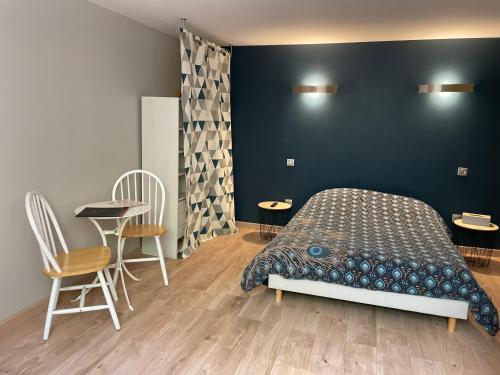 une chambre avec un lit, une table et des chaises dans l'établissement Chambre indépendante 25 m2 au calme avec piscine et terrain de pétanque, à Lieuran-lès-Béziers