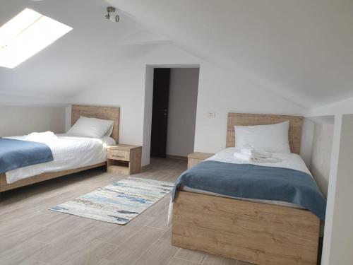 a bedroom with two twin beds and a skylight at Pensiunea Lotus Corbu in Corbu