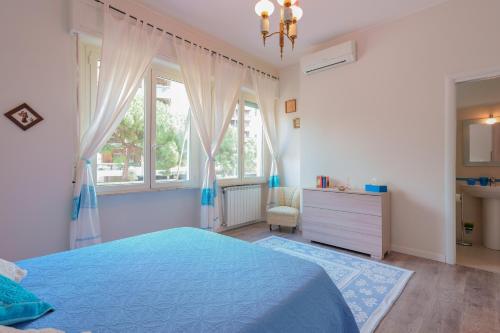 a bedroom with a blue bed and a window at Fortyfourbandb in Cagliari