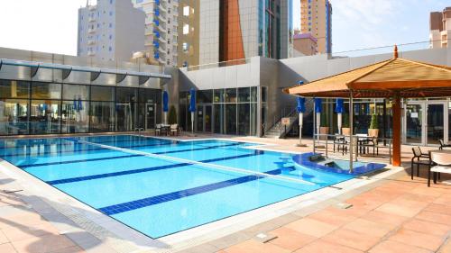 a large swimming pool in a building at Holiday Inn Kuwait by IHG in Kuwait