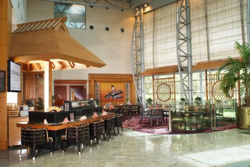 a restaurant with tables and chairs in a building at Holiday Inn Kuwait by IHG in Kuwait
