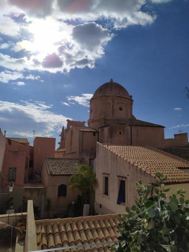 a view of a building with a church in the background at Palazzo Salomone in Siracusa