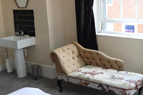 een badkamer met een stoel en een wastafel bij Huntsman Tavern in Salisbury
