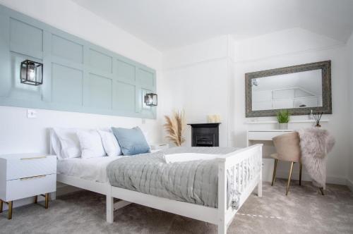 滕比的住宿－Newell Hill Cottage - 3 Bedroom Cottage - Tenby，白色的卧室配有白色的床和镜子