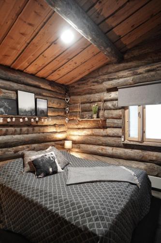 a bedroom with a bed in a log cabin at RukaTupasvilla in Ruka