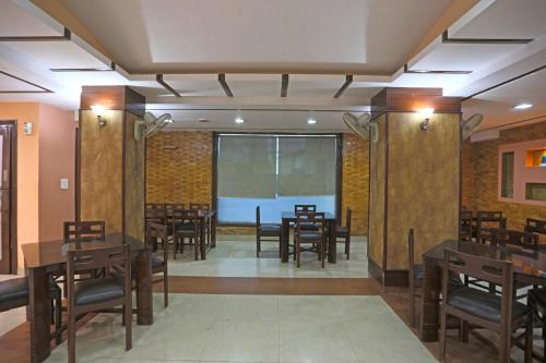 uma sala de jantar com mesas e cadeiras e um ecrã de projecção em Hotel The Tourist - 1 min from New Delhi Railway Station em Nova Deli