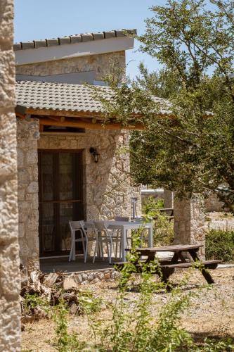 a table and chairs on the porch of a stone house at Omalos Village in Omalós