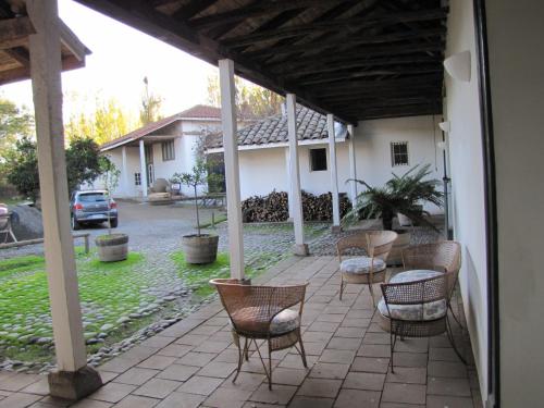 a patio with chairs and a table and a house at Hotel Plaza Malloa in Malloa