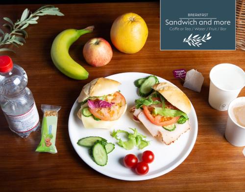 einen Teller mit Essen mit zwei Sandwiches sowie Obst und Gemüse in der Unterkunft area24|7 Europaplatz in Karlsruhe