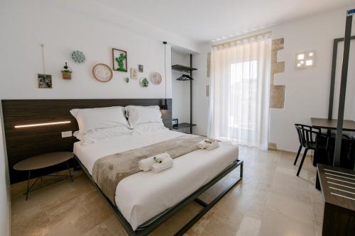 a bedroom with a large bed and a table at IBLA ROOMS in Ragusa